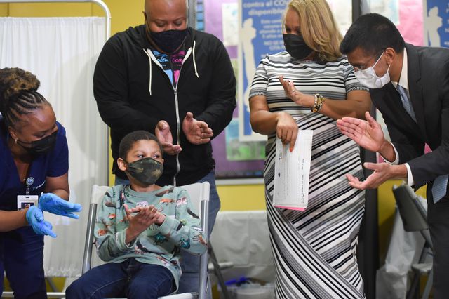 A child gets a fist pump from Schools Chancellor Meisha Porter after getting vaccinated